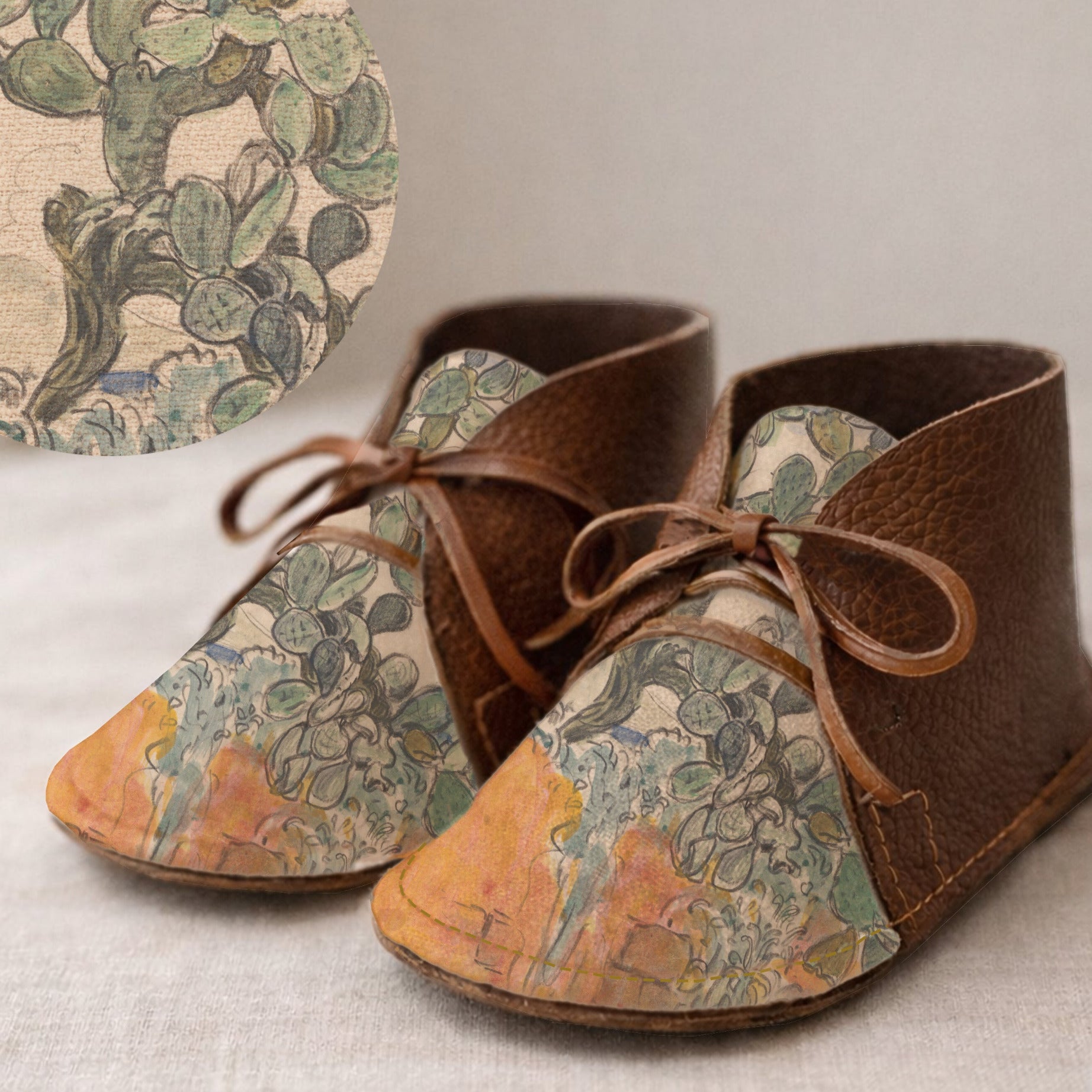 Pair of brown leather shoes with cactus pattern on a light background